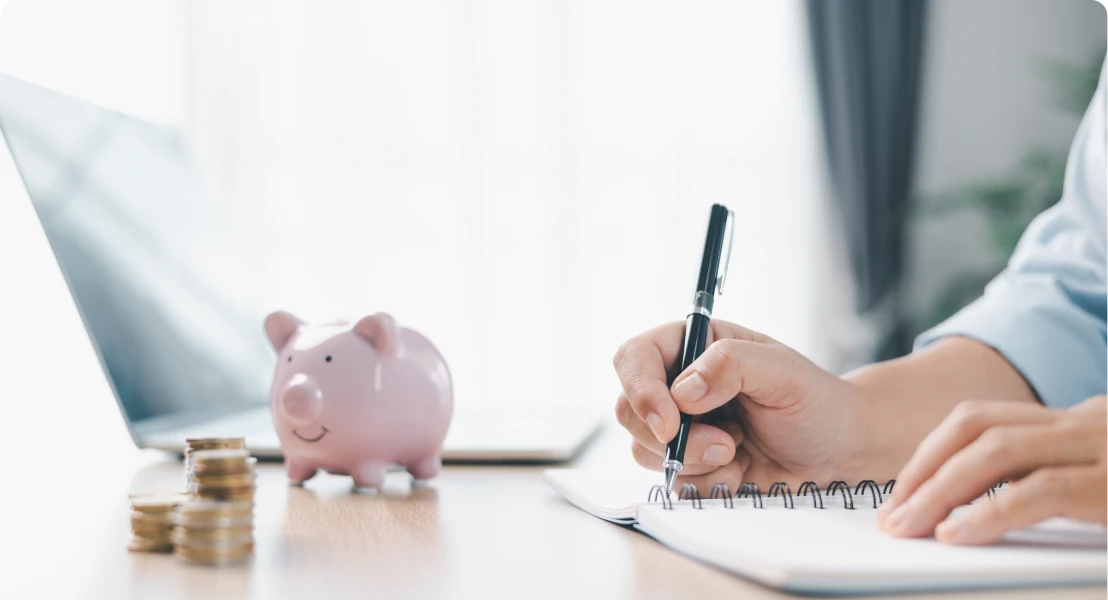 Writing notes with piggy bank and coins.