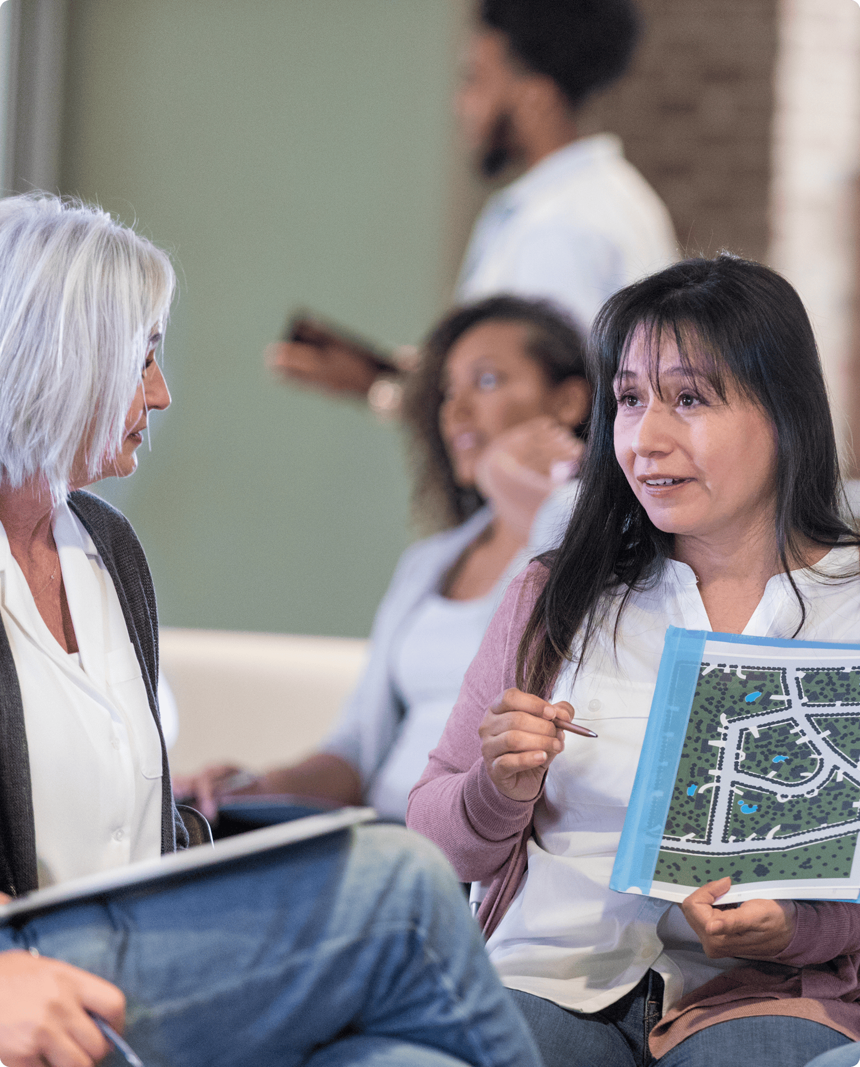 Women discussing urban planning documents together.